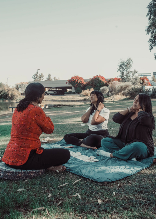 Yoga teacher training two students in grass at Rising Embers Therapy and Wellness in Chandler, Az